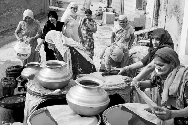 Women and Drinking Water Challenges - Women preparing to transfer home their weekly ration of drinking water collected from a tanker in a village in South-West district, National Capital Territory of Delhi